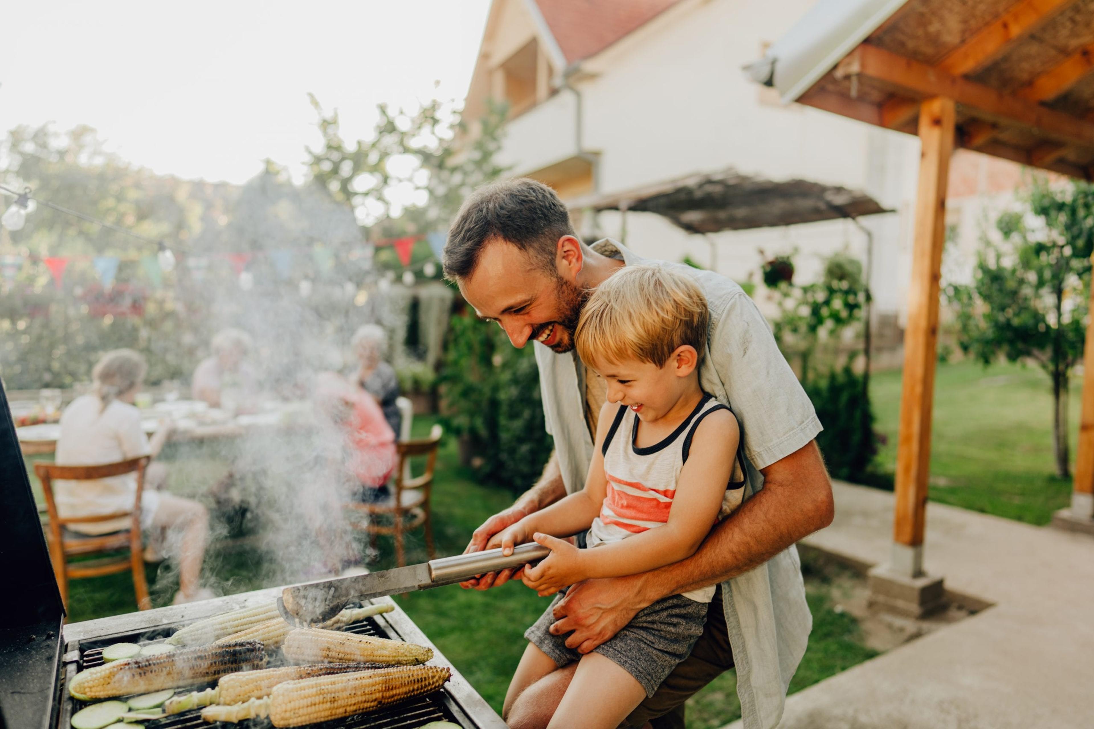 Photo of father showing his boy how to grill