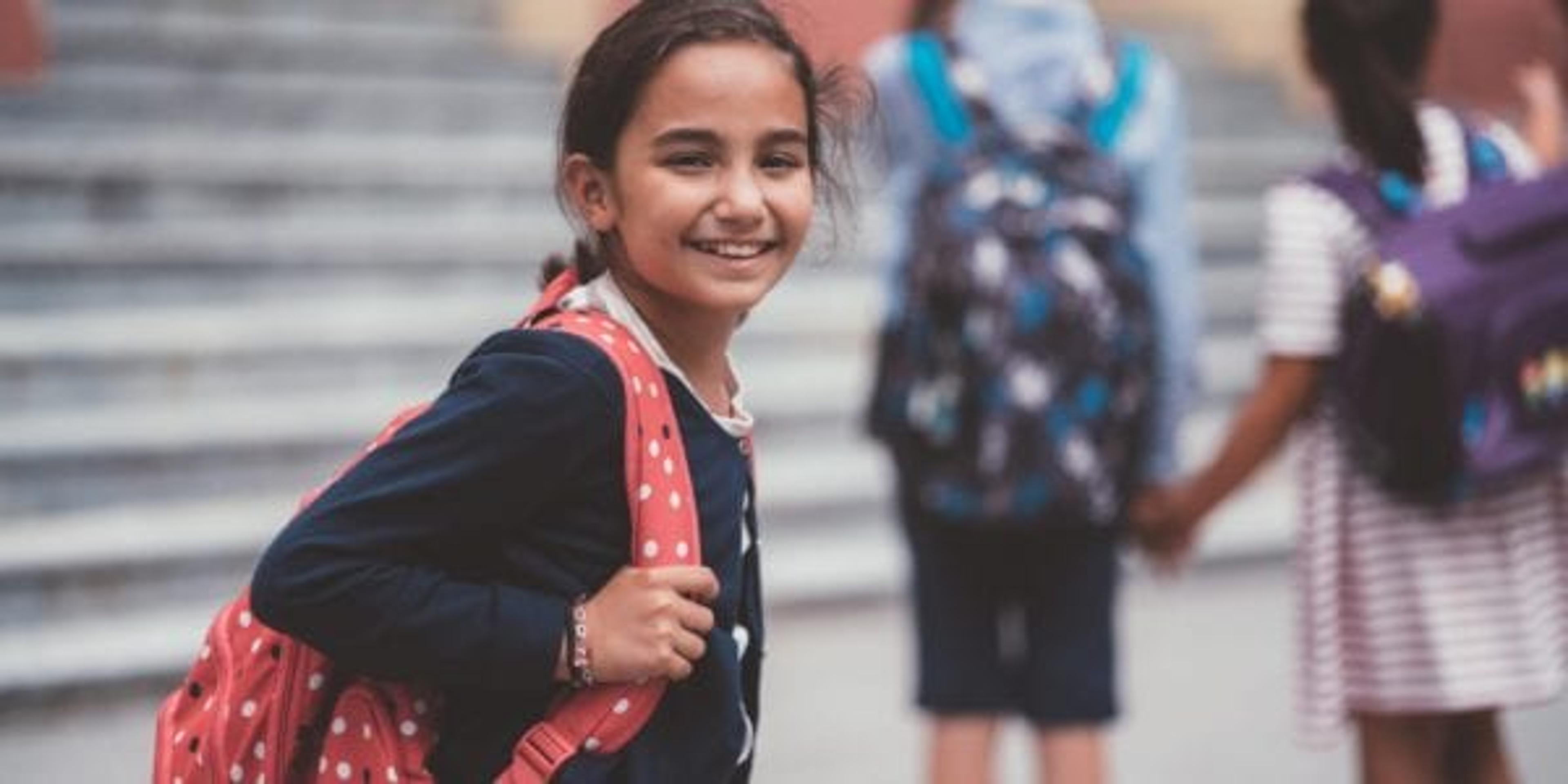 Little girl smiling on her first day of school